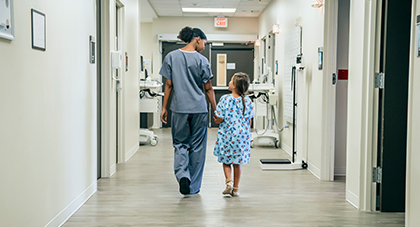 image of a nurse walking with a little girl down a hospital hallway