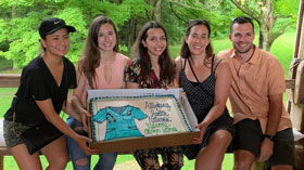 Residents sitting on a bench holding a big cake