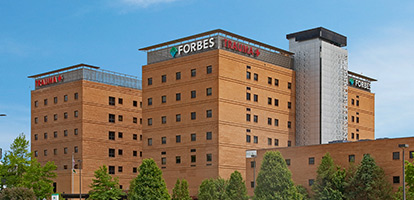 A view of Forbes Hospital with a blue sky.