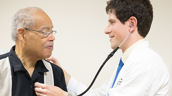 A doctor using a stethoscope on a patient.
