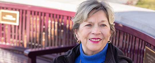 Barbara Lentz is sitting on a bench outside.